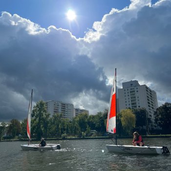 2 Jollen auf dem Main vor der Kullise des Offenbacher Mainufers.
Eindrucksvolle dunkle Wolken mit einer Lücke durch die die Sonne zu sehen ist